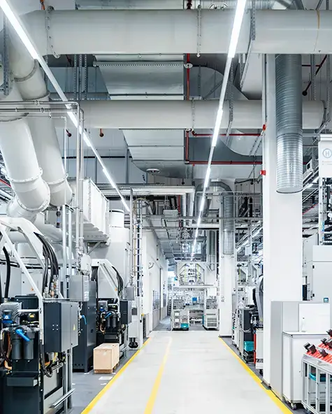 Modern factory floor with automated machinery and industrial ducting