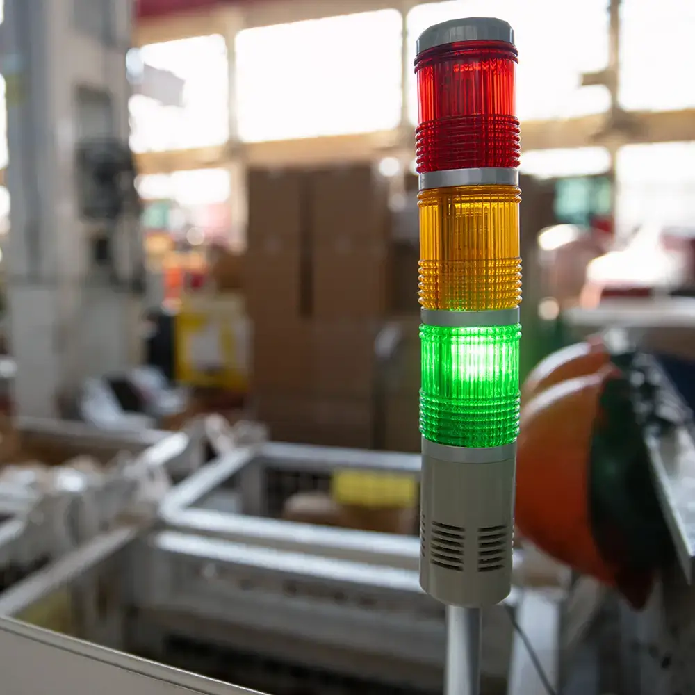 Stacked signal light showing green on active packaging line in industrial packaging production facility